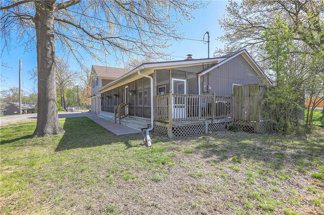 exterior space featuring a sunroom and a lawn