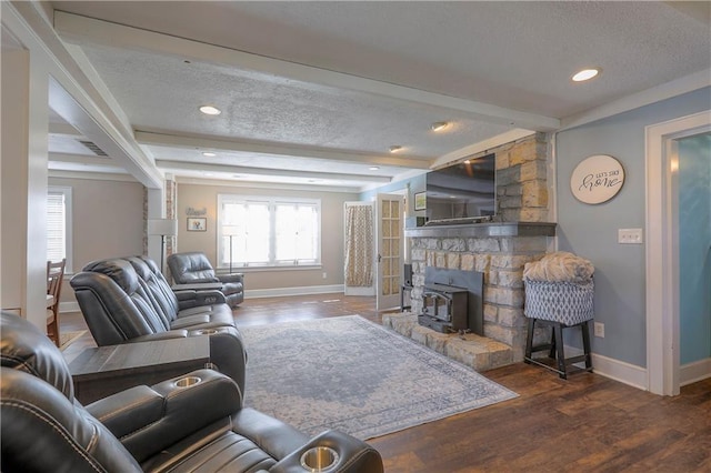 living room featuring a textured ceiling, baseboards, and beam ceiling