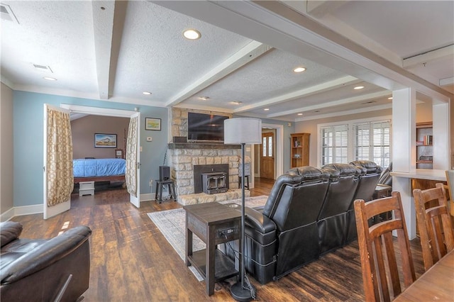 living area with visible vents, a textured ceiling, baseboards, and wood finished floors