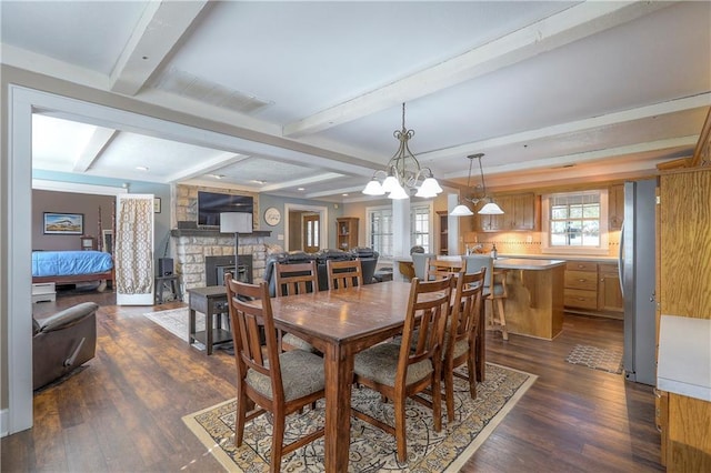 dining area with visible vents, an inviting chandelier, a fireplace, dark wood finished floors, and beamed ceiling