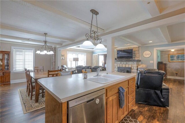 kitchen with beamed ceiling, a fireplace, dishwasher, a sink, and open floor plan