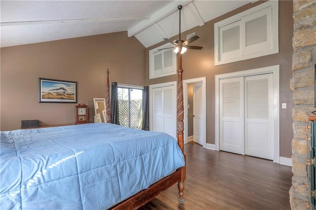 bedroom featuring baseboards, two closets, beamed ceiling, wood finished floors, and high vaulted ceiling