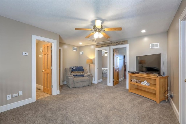 living area featuring light colored carpet, ceiling fan, and visible vents
