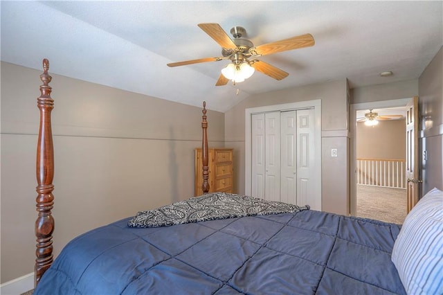 carpeted bedroom featuring a closet, ceiling fan, baseboards, and lofted ceiling