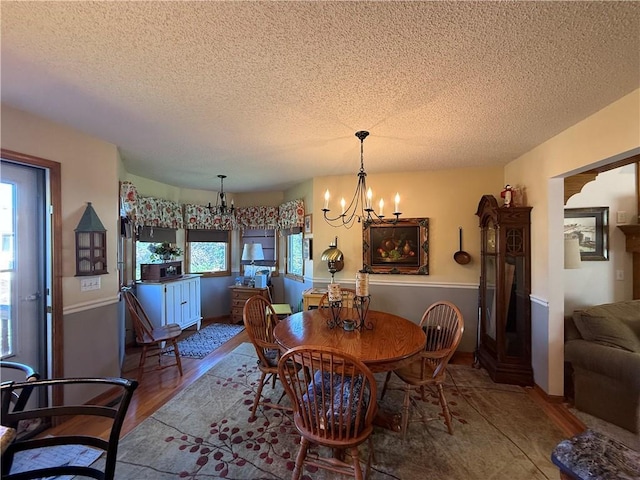 1200 Susan St, Kearney, MO 64060 - dining space featuring a chandelier, a textured ceiling, and wood finished floors