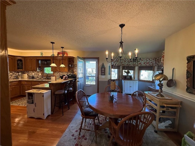 1200 Susan St, Kearney, MO 64060 - dining space featuring a chandelier, a textured ceiling, light wood-type flooring, and healthy amount of natural light
