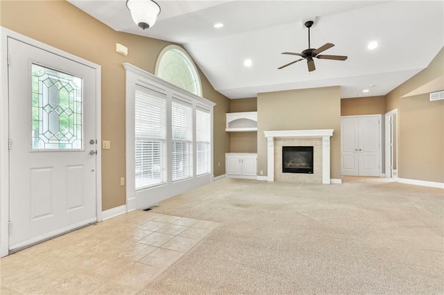 5428 W 145th Ter, Leawood, KS 66224 - unfurnished living room with vaulted ceiling, a ceiling fan, built in shelves, a tiled fireplace, and baseboards