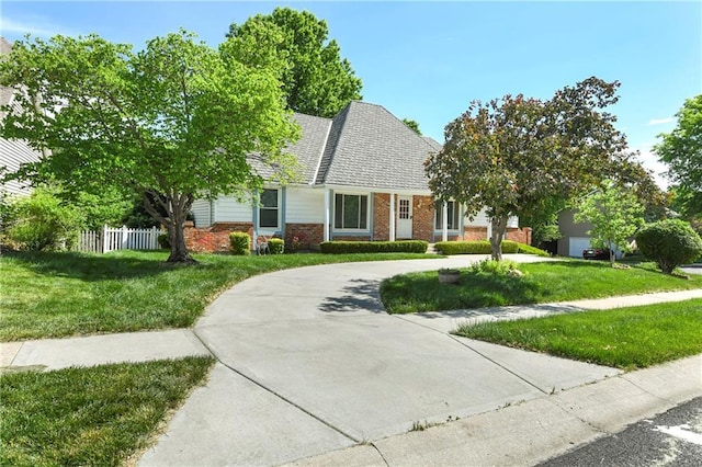 view of front facade featuring curved driveway and brick siding