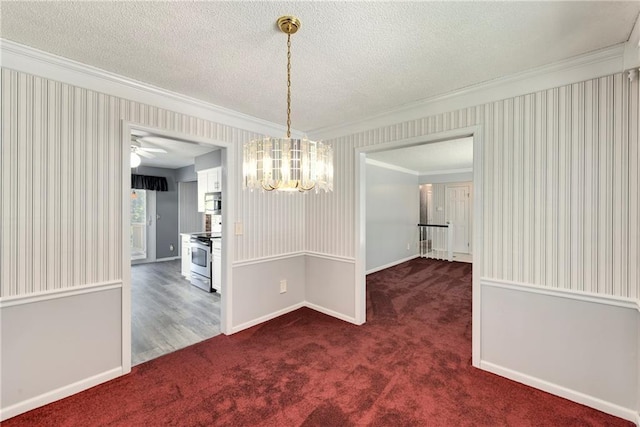 unfurnished dining area featuring ornamental molding, a chandelier, dark colored carpet, wallpapered walls, and baseboards