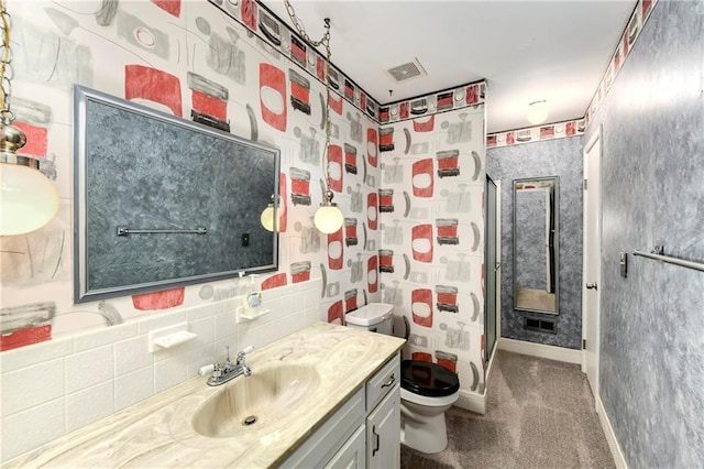 full bathroom with toilet, vanity, baseboards, and a shower stall