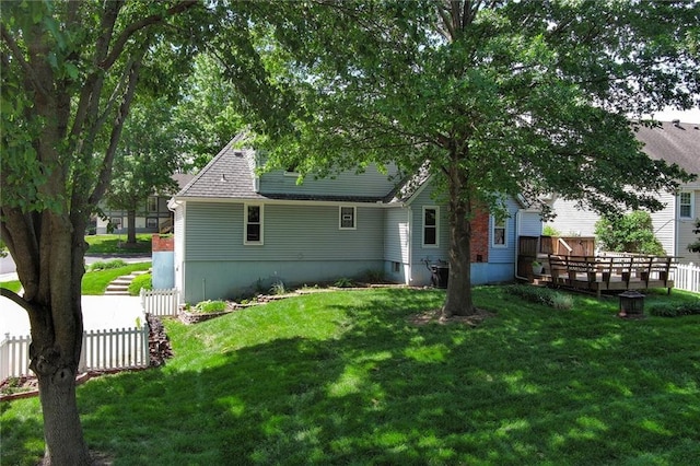 back of house featuring a wooden deck and roof with shingles