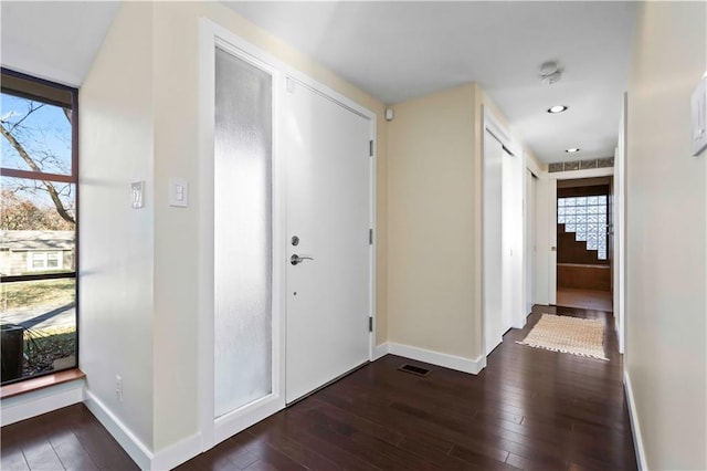 foyer featuring visible vents, baseboards, and dark wood finished floors