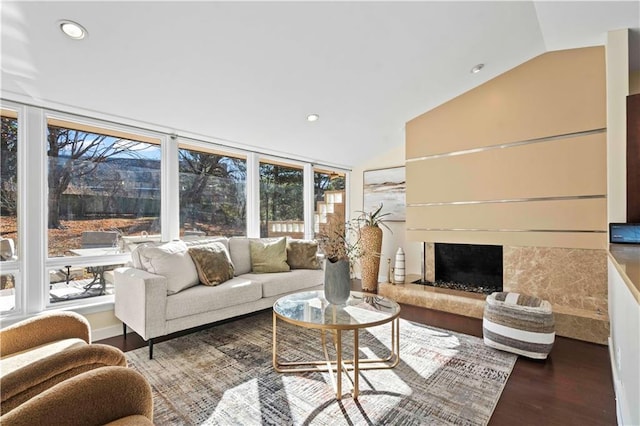 living room with recessed lighting, a premium fireplace, vaulted ceiling, and wood finished floors