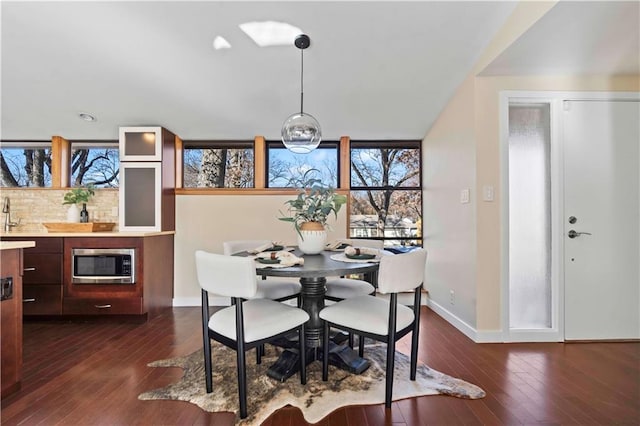 dining area featuring dark wood-style flooring and baseboards