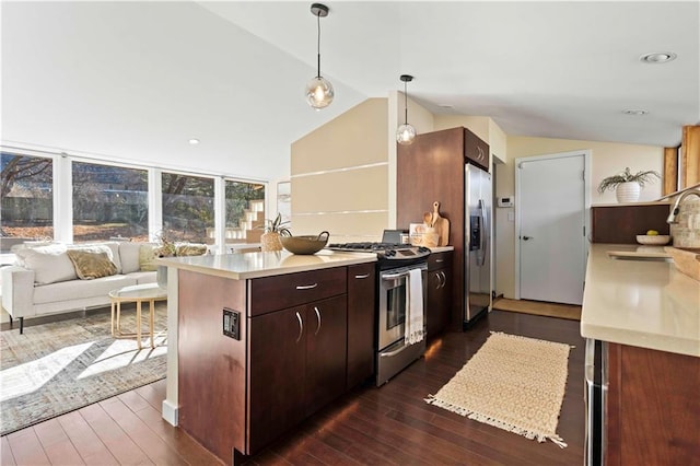 kitchen with a peninsula, light countertops, lofted ceiling, stainless steel appliances, and a sink