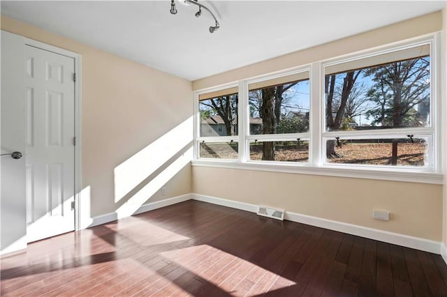 interior space featuring track lighting, visible vents, baseboards, and dark wood-style floors