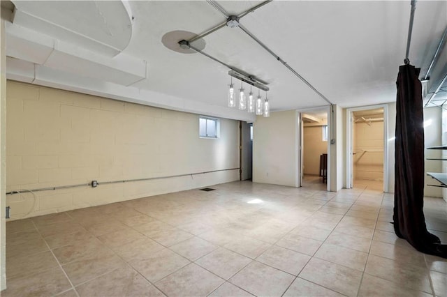 basement featuring light tile patterned floors and concrete block wall