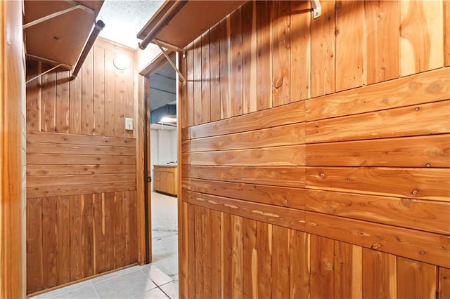 hall featuring wood walls and tile patterned floors