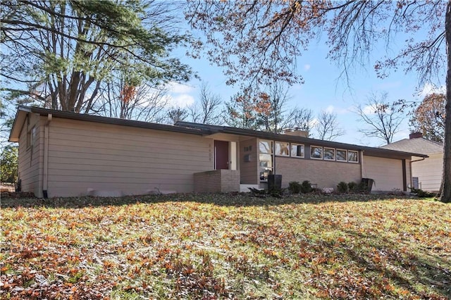 view of front of house with a garage, a front lawn, and brick siding
