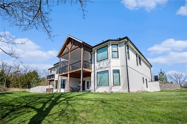 back of house featuring a sunroom, a yard, and a patio