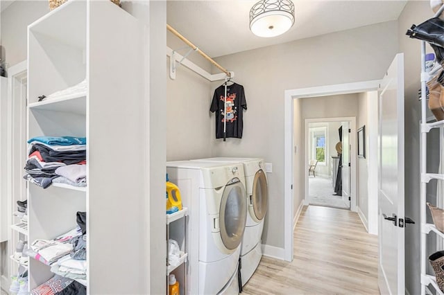 laundry area with baseboards, light wood-style flooring, independent washer and dryer, and laundry area