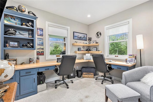 office space with recessed lighting, plenty of natural light, built in desk, and carpet