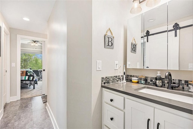 bathroom with vanity, baseboards, recessed lighting, and ceiling fan