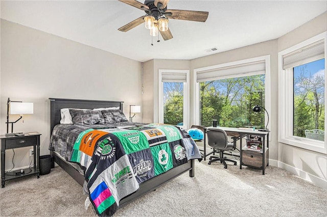 carpeted bedroom featuring baseboards, ceiling fan, and visible vents