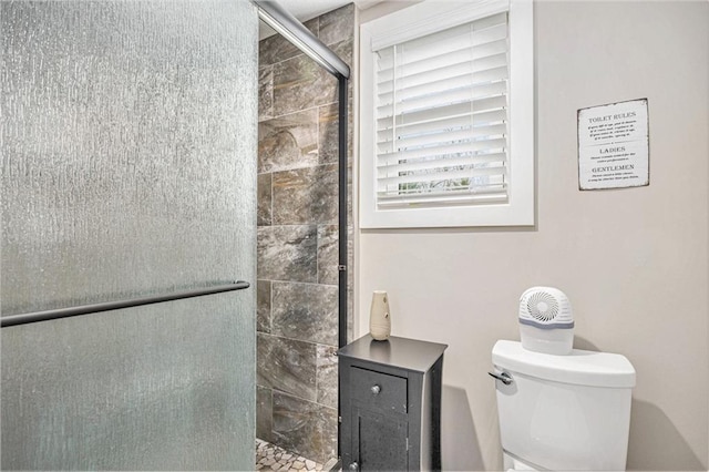 bathroom featuring a stall shower and toilet