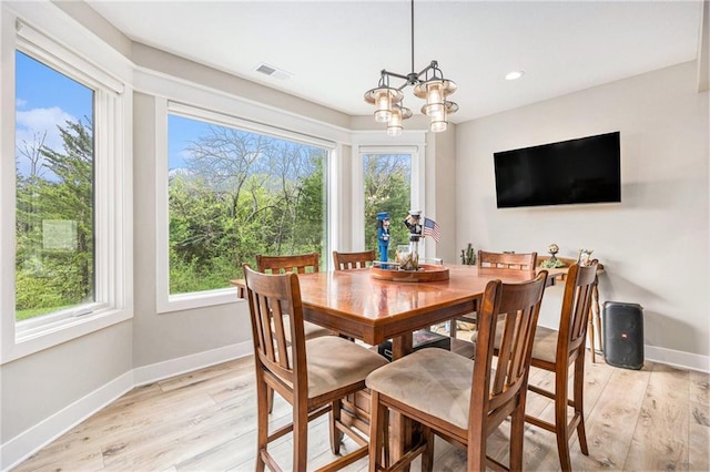 dining area featuring baseboards, a wealth of natural light, light wood-style flooring, and visible vents