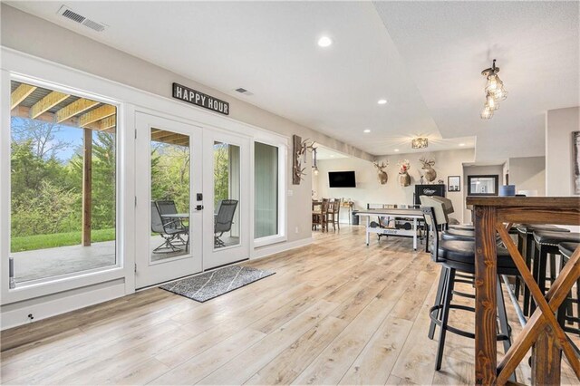 interior space with light wood-type flooring, french doors, recessed lighting, and visible vents
