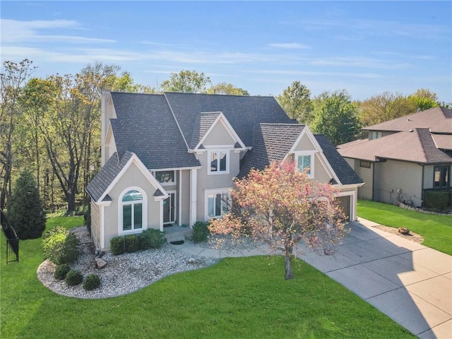 traditional-style house featuring stucco siding, a front lawn, and driveway