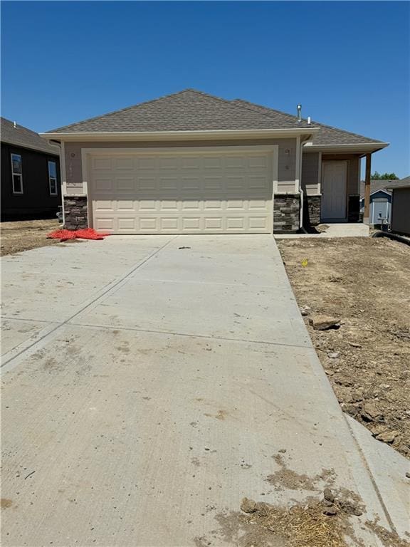 2107 Brook Ridge Cir, Tonganoxie, KS 66086 - view of front facade with stone siding, driveway, and a garage