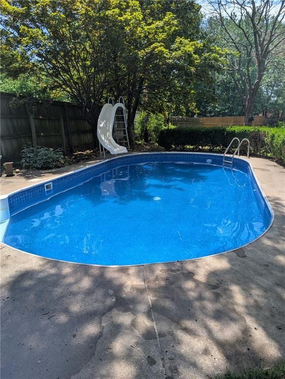 712 NW 10th St, Blue Springs, MO 64015 - view of swimming pool featuring a water slide, a fenced backyard, and a patio