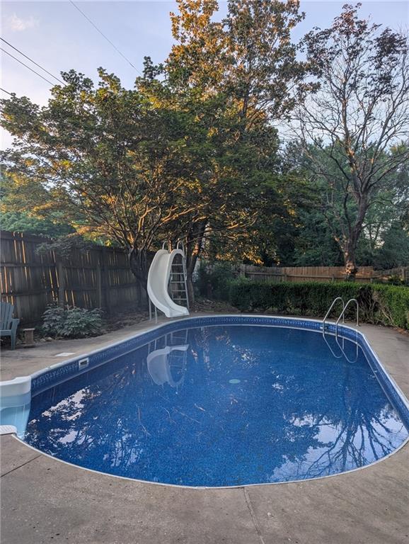 712 NW 10th St, Blue Springs, MO 64015 - view of pool with a water slide and a fenced backyard