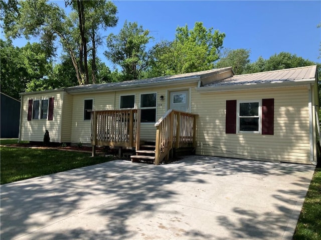 view of front of property featuring metal roof and a deck