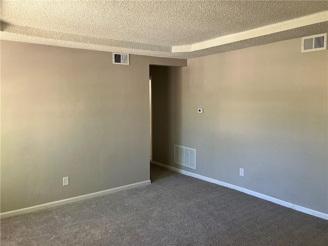 unfurnished room featuring a textured ceiling, dark colored carpet, and baseboards