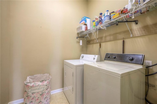 laundry room featuring baseboards, tile patterned floors, washing machine and clothes dryer, and laundry area
