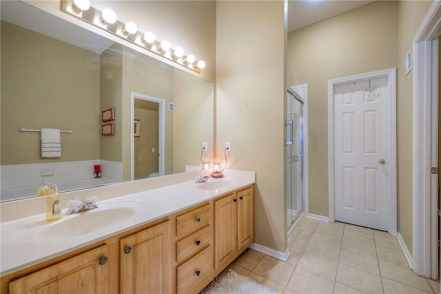 bathroom featuring a stall shower, tile patterned flooring, and a sink