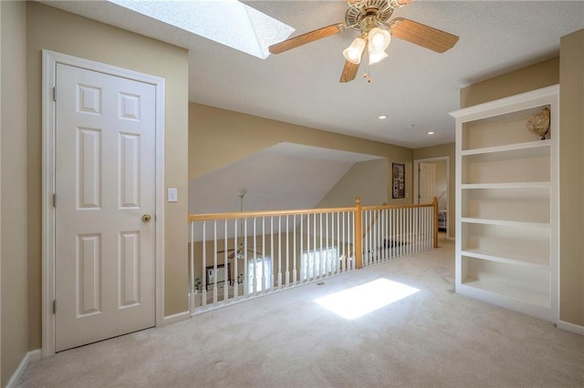 interior space with baseboards, recessed lighting, a skylight, and a ceiling fan
