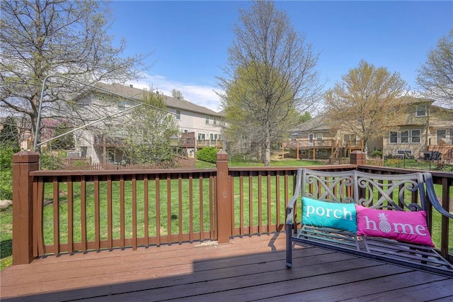 wooden terrace featuring a residential view and a yard