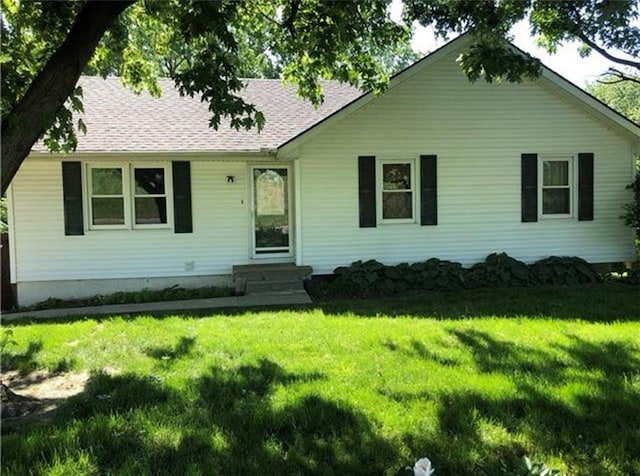 view of front of property featuring a front yard and roof with shingles