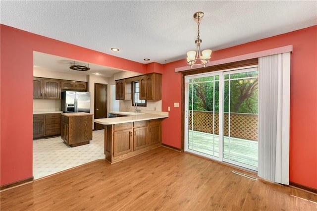 32832 195th St, Leavenworth, KS 66048 - kitchen with stainless steel fridge, light wood-style floors, light countertops, a sink, and a chandelier