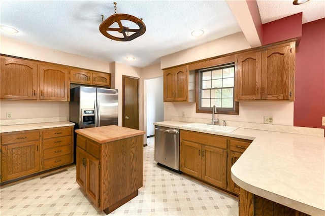 32832 195th St, Leavenworth, KS 66048 - kitchen with a sink, appliances with stainless steel finishes, a textured ceiling, light flooring, and a center island