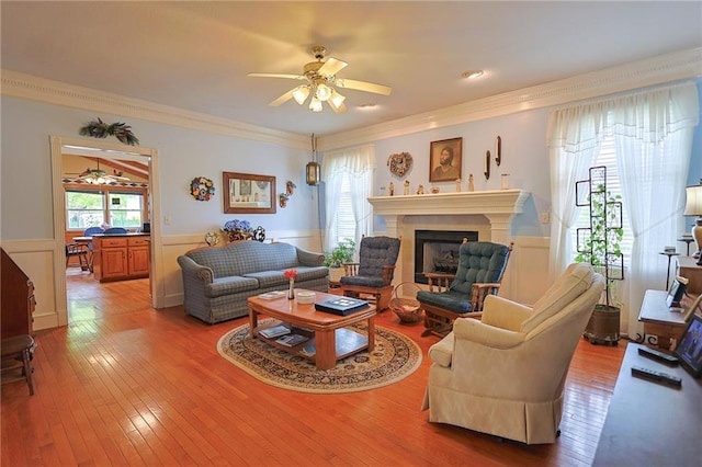 15404 NE 181st St, Holt, MO 64048 - living room with ceiling fan, a wainscoted wall, hardwood / wood-style floors, crown molding, and a fireplace
