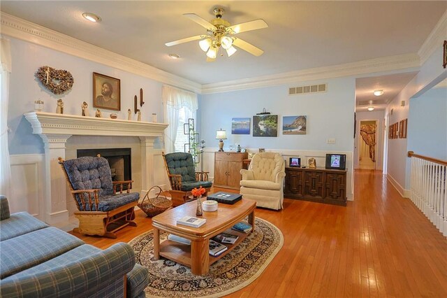15404 NE 181st St, Holt, MO 64048 - living area featuring ceiling fan, hardwood / wood-style flooring, a fireplace, and crown molding