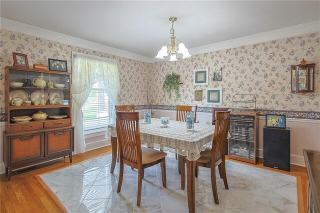 15404 NE 181st St, Holt, MO 64048 - dining area with crown molding, a chandelier, wallpapered walls, light wood-style flooring, and a wainscoted wall