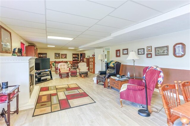 15404 NE 181st St, Holt, MO 64048 - living area featuring wood finished floors, a paneled ceiling, and a fireplace with raised hearth