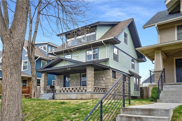 3009 Campbell St, Kansas City, MO 64109 - american foursquare style home featuring a porch, stone siding, and a front lawn