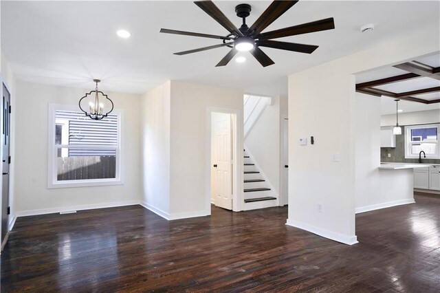 3009 Campbell St, Kansas City, MO 64109 - unfurnished living room with baseboards, a sink, dark wood-style floors, stairway, and ceiling fan with notable chandelier